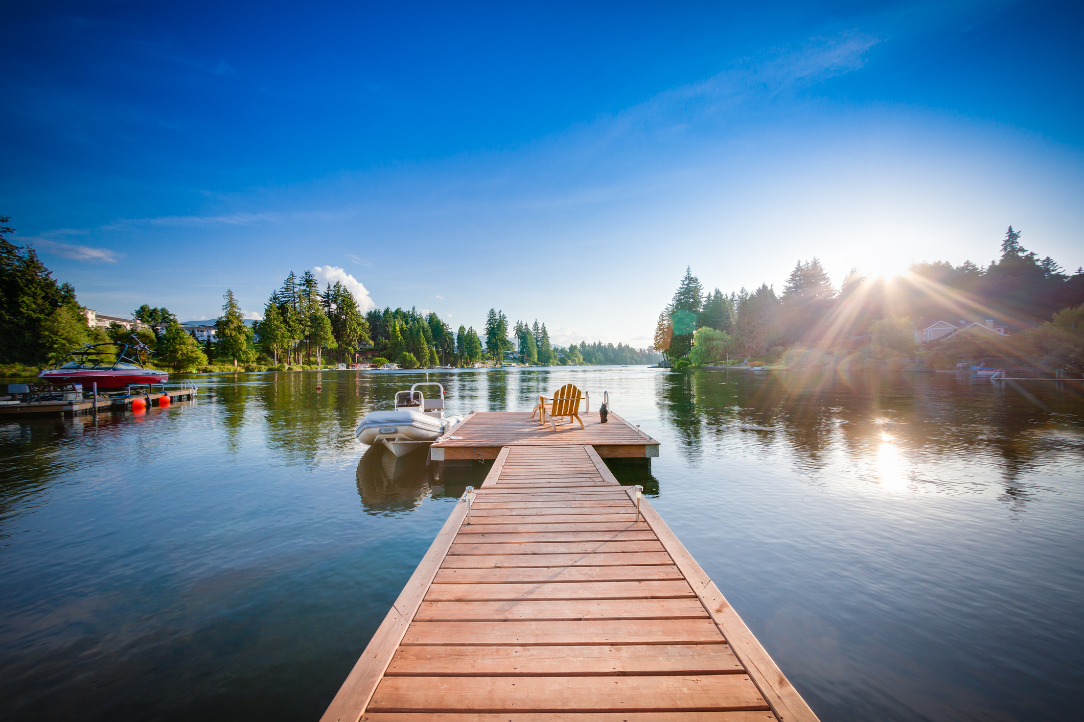 Wooden dock extending into a calm lake with a boat alongside