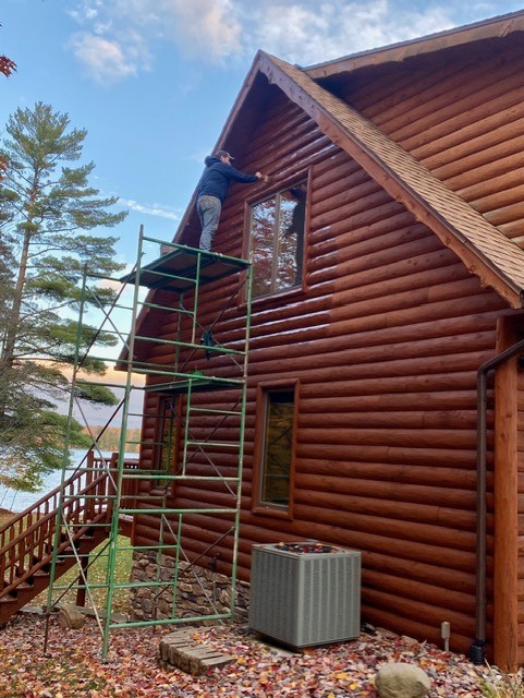 Restoration work on a log home gable beside the lake