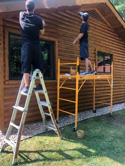 Crew working on the exterior finish of a log home